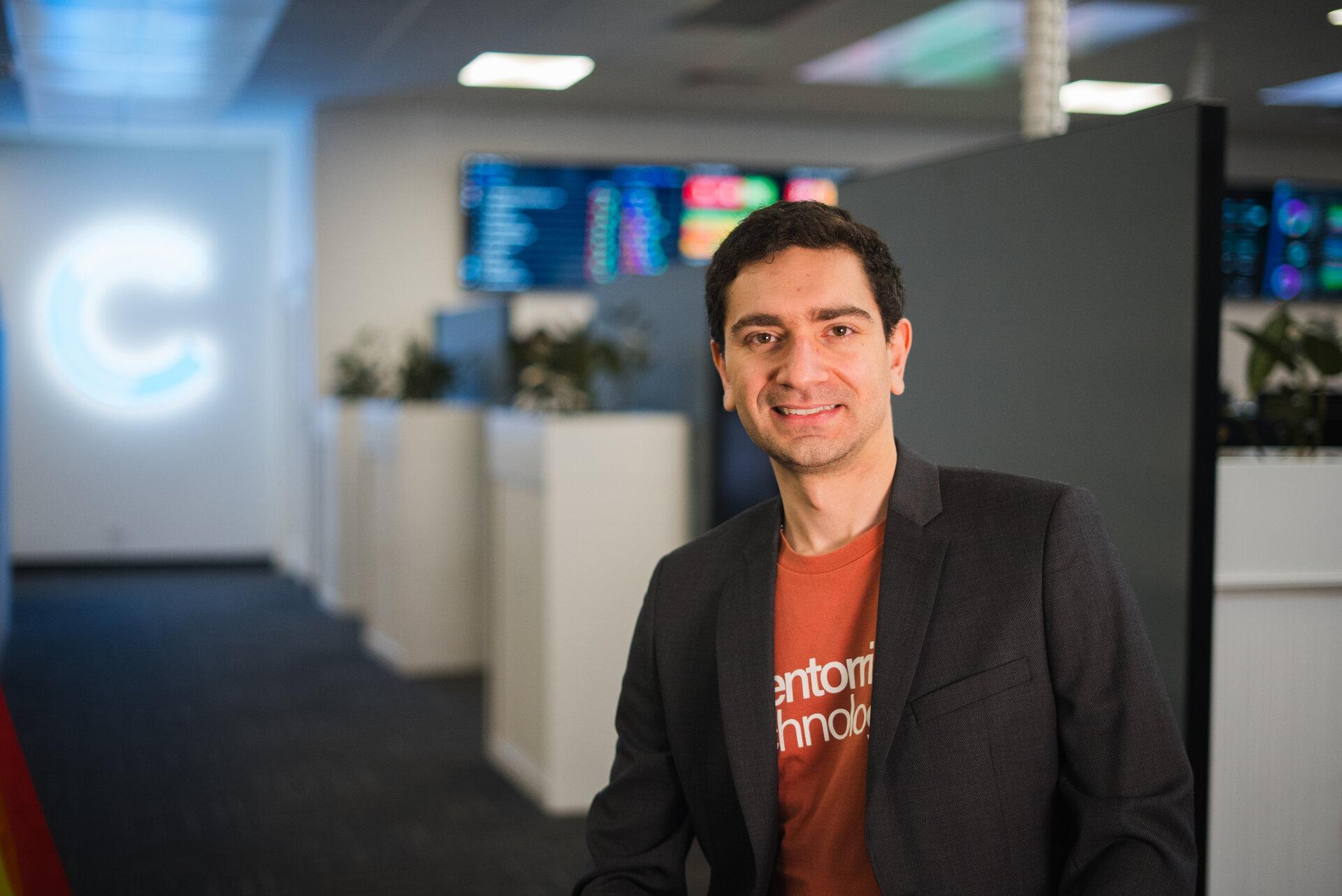 Nicholas Iacobucci smiling to the camera in front of the CT logo